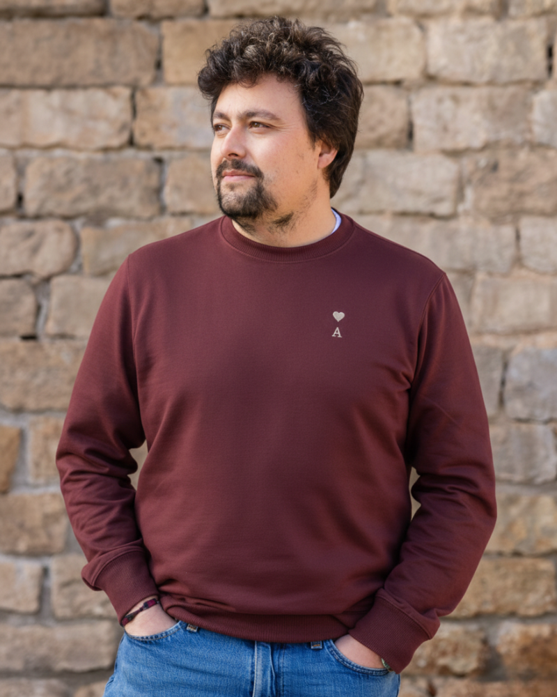 Sudadera personalizada granate con inicial y corazón bordado llevada por modelo en look casual