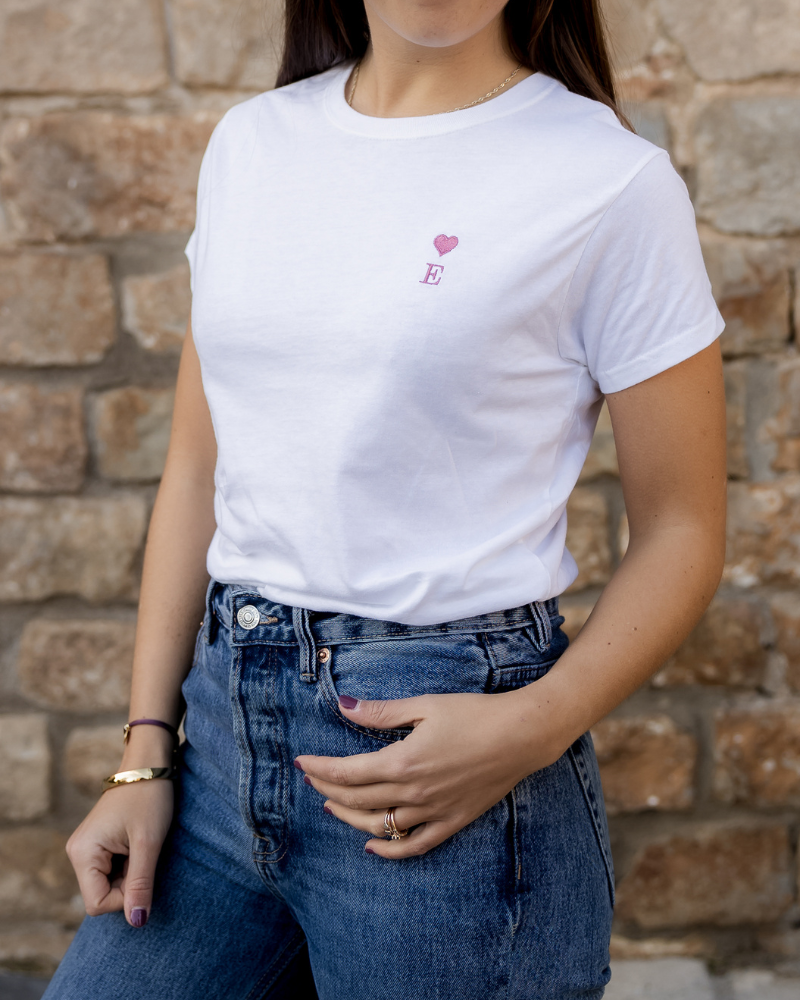 Detalle del corazón y la inicial bordados en el pecho izquierdo de camiseta personalizada
