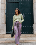 Mujer llevando el Jersey Blanca verde combinado con pantalón de talle alto para look casual