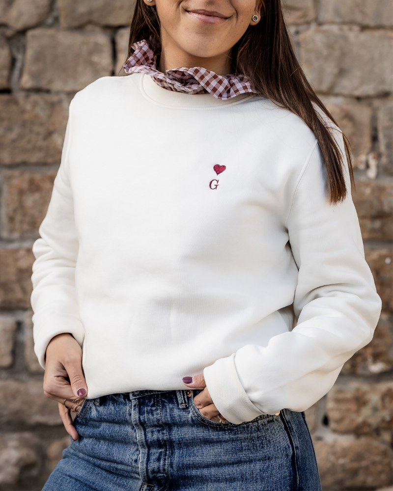 Sudadera beige de mujer personalizada con inicial y corazón bordado llevada por modelo en look casual