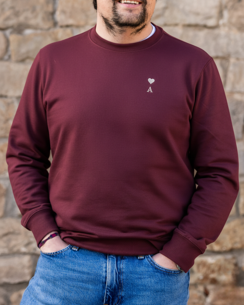 Sudadera personalizada granate con inicial y corazón bordado llevada por modelo en look casual