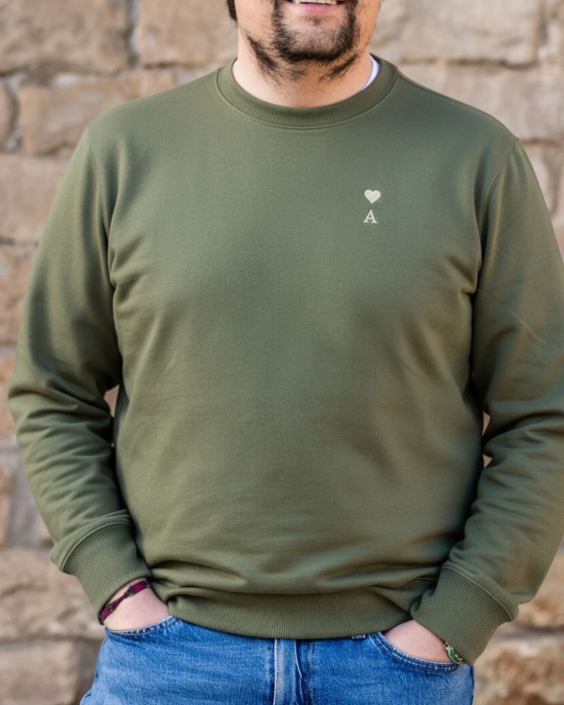 Sudadera personalizada kaki con inicial y corazón bordado llevada por modelo en look casual