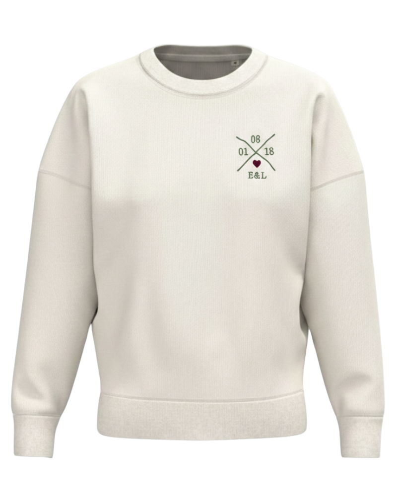 Sudadera beige mujer vista frontal, con X personalizada bordada y corazón granate en pecho izquierdo