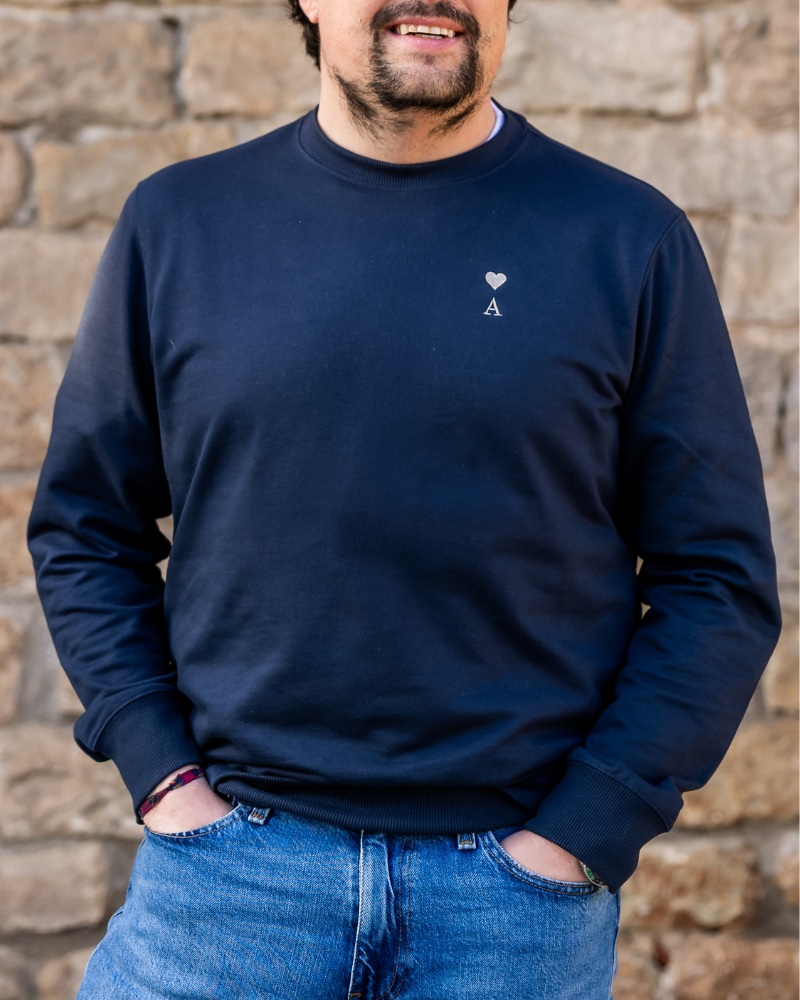 Sudadera azul marino personalizada con inicial y corazón bordado llevada por modelo en look casual
