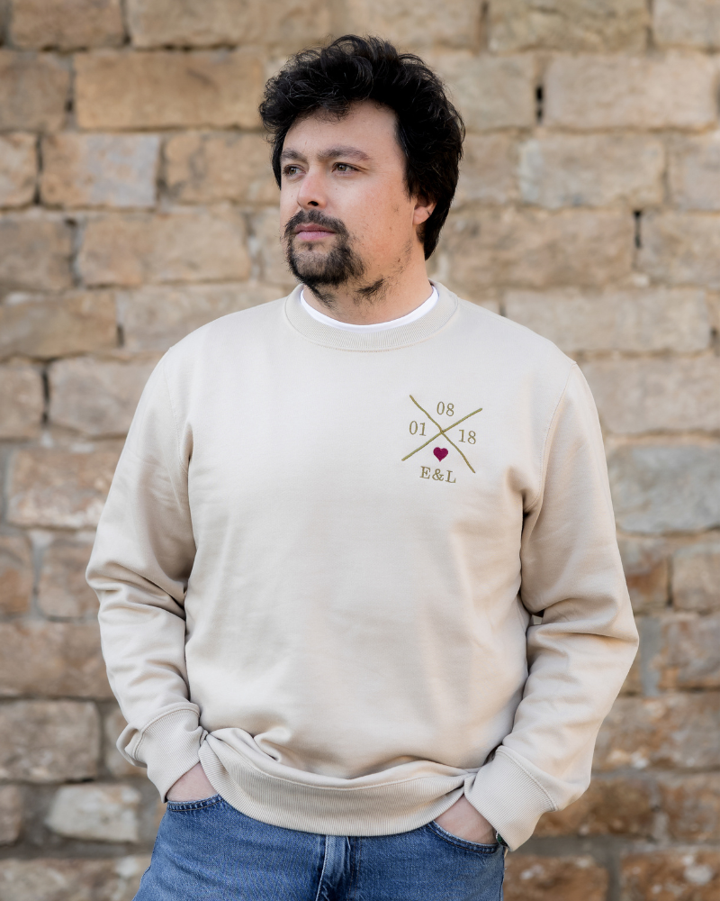 Modelo vistiendo sudadera beige unisex, vista frontal, personalizada y corazón granate bordado en pecho izquierdo