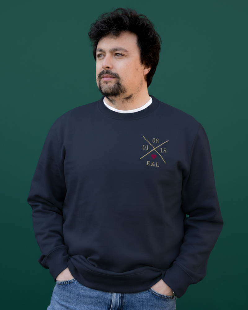 Modelo vistiendo sudadera azul marino unisex, vista frontal, X personalizada y corazón granate bordado en pecho izquierdo